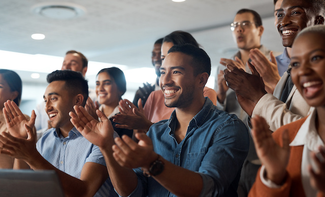 A group of diverse employees applaud and support an achievement