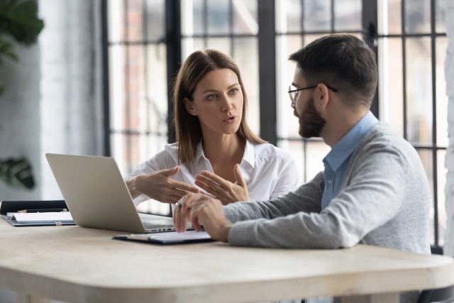 A female director communicates with a male client in the workplace