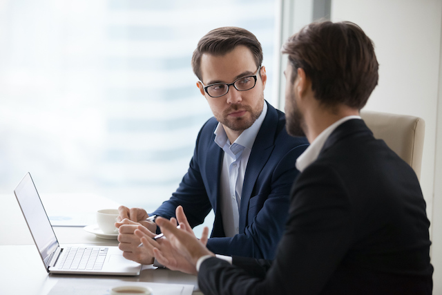 A male manager gets support from his supervisor to help train his employees.