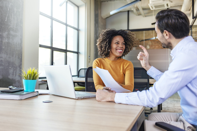 A male manager works with a female employee to assess which soft skills she needs to develop.