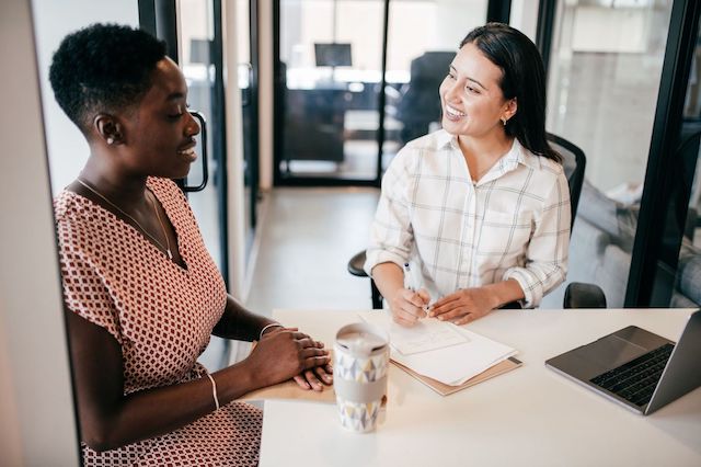 A Latina hiring manager interviews a female Black candidate.