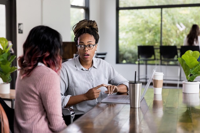 A manager checks in with her employee about her changes in responsibilities following layoffs