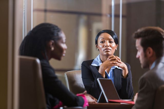 Clashing cultures can be a problem after a merger, as shown in this image of three employees at a meeting.