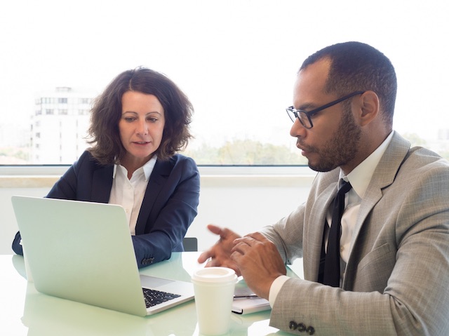 Two managers review a preliminary layoff list