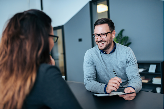 A male hiring manager interviews a female candidate.