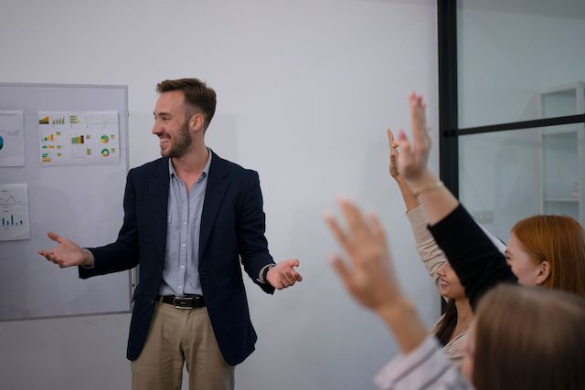 A man who has taken leadership development coursework leads a meeting.