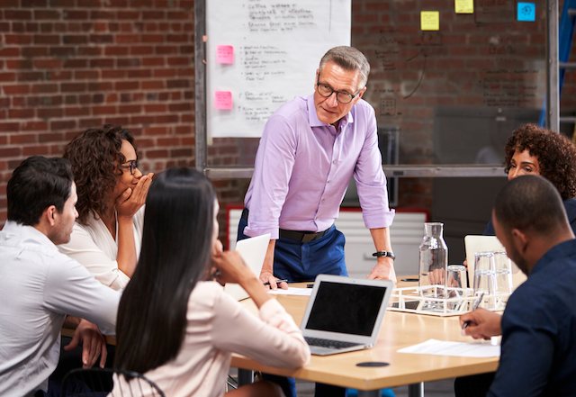 A company's leadership team meets to review employee survey feedback.