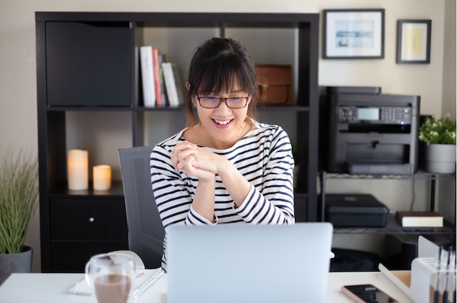 An Asian woman works with her outplacement coach by video chat at home.