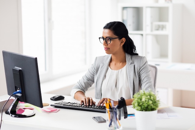 A female manager who knows how to reject an interviewee emails a candidate to let them know they haven't been selected