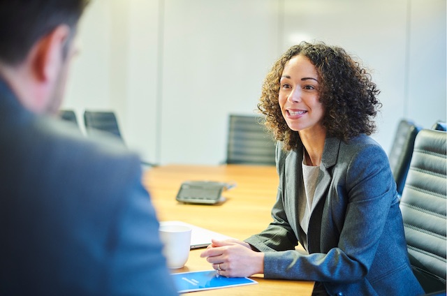 A female employees responds to feedback from her male manager in a meeting.