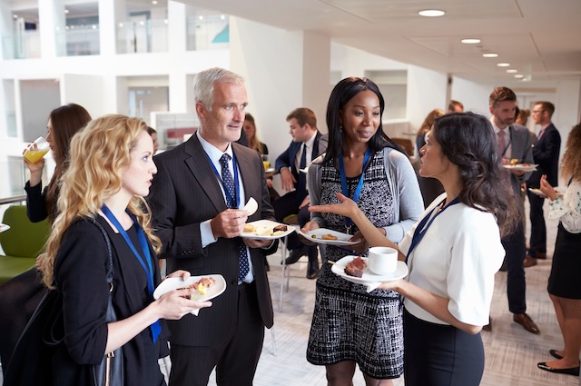 One example of a professional development goal is to network with ten other professionals, which is why this woman is speaking with two women and a man at a conference.