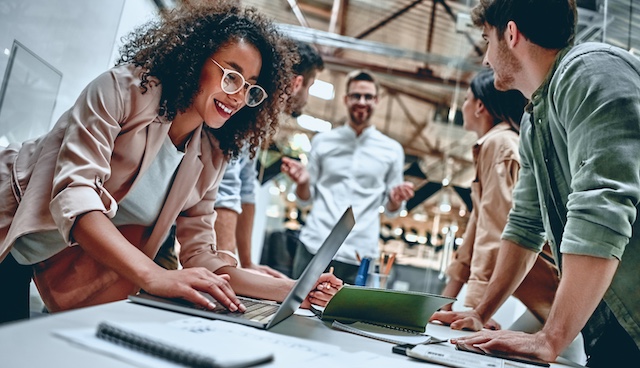 A diverse group of young colleagues collaborate on a project.