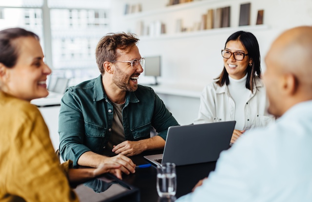 A young Black woman leads her team in a project meeting