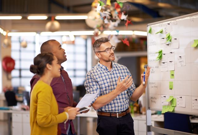 A young Black woman leads her team in a project meeting