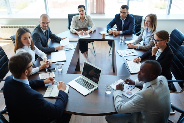 A young Black woman leads her team in a project meeting