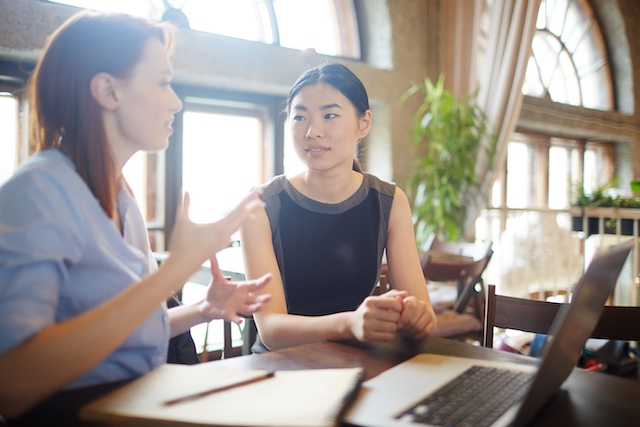 Young Asian female employee has a discussion with her female manager.