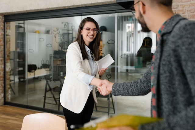 A young woman shakes the hand of someone helping her with her career transition