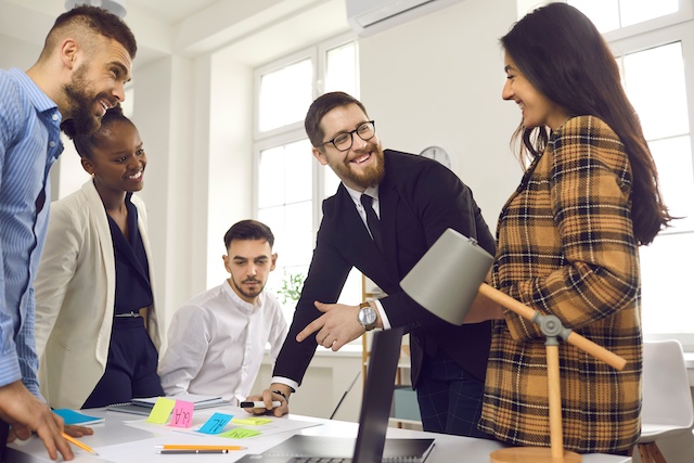 A diverse team of employees work together on a project