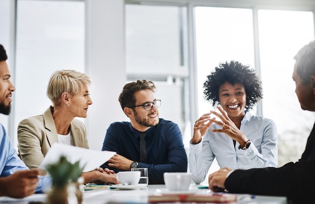 A diverse work team collaborates at a meeting.