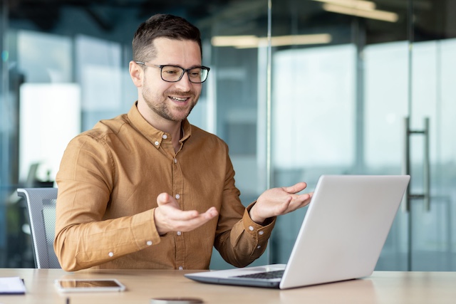 A male career coach has a virtual session with a job seeker on his laptop.