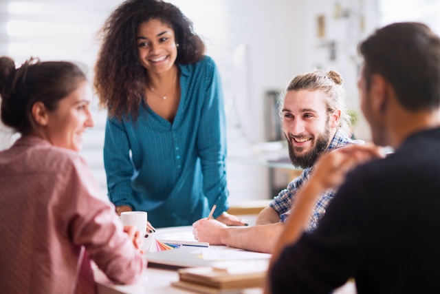 A young Black woman leads her team in a project meeting