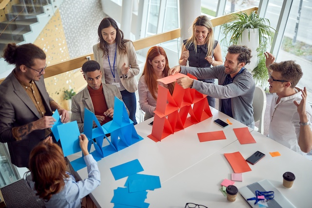 A diverse group of young employees play a game at work