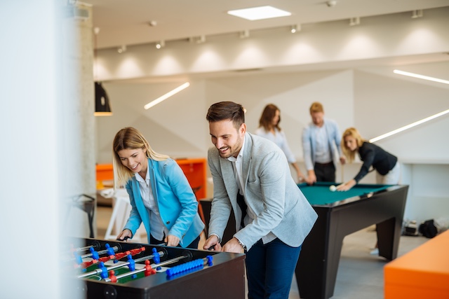 Coworkers play foosball in an office game room