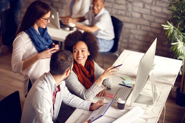 A young Black woman leads her team in a project meeting