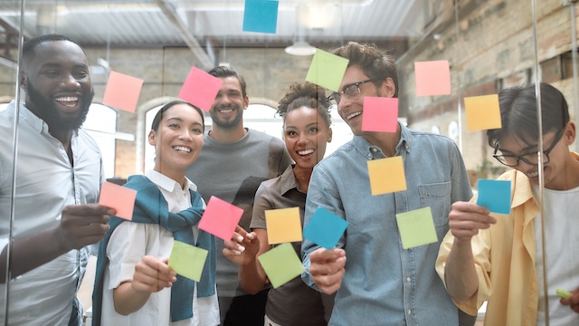 A young Black woman leads her team in a project meeting