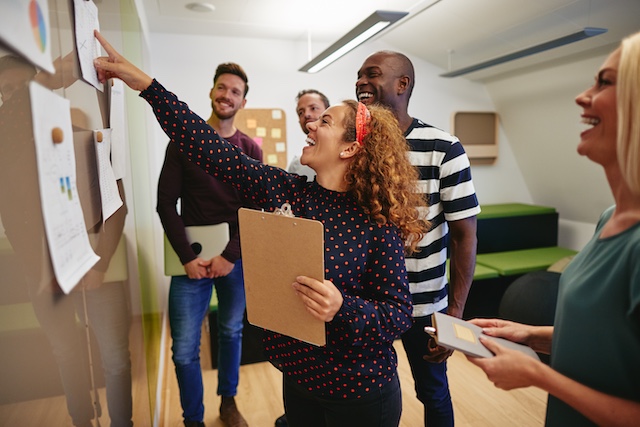 employee-training-1 A group of diverse employees use learnings from employee training and workshops to collaborate effectively