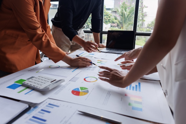 Managers analyze reports showing organizational performance