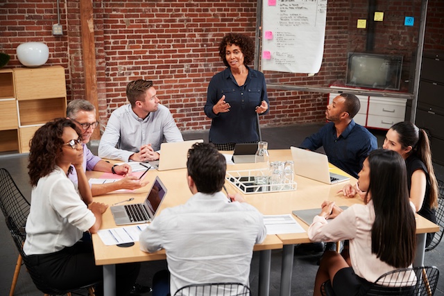A woman leads a meeting of diverse team members