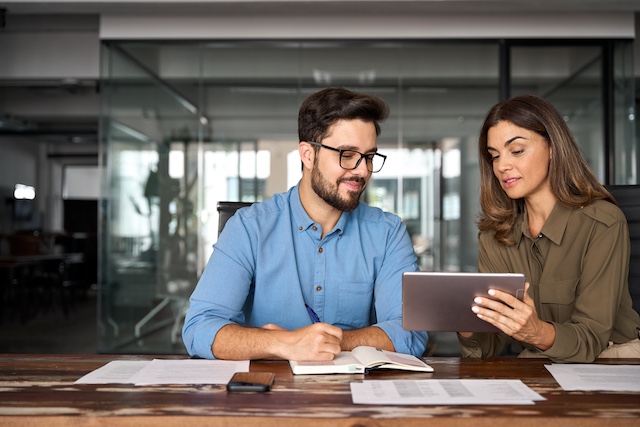 A woman manages her high-performing male employee in a meeting