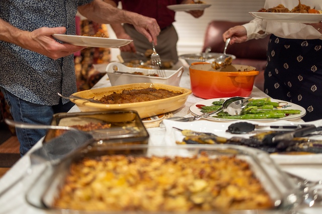 A buffet table filled with holiday dishes at a potluck