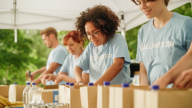 A group of employees volunteer to prepare food kits