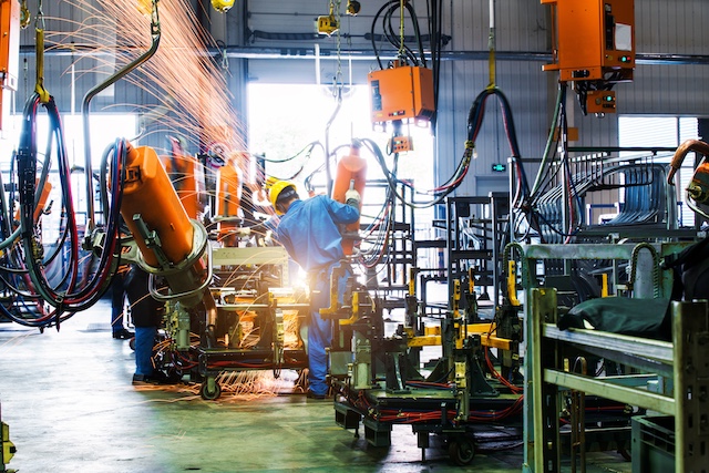 A factory worker welds in a car factory