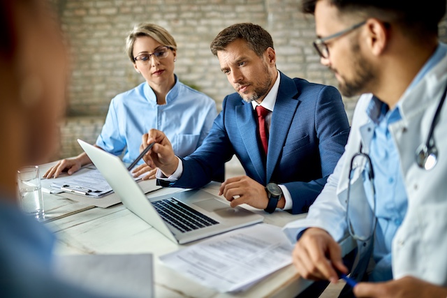 A team of healthcare professionals reviews reports in a meeting