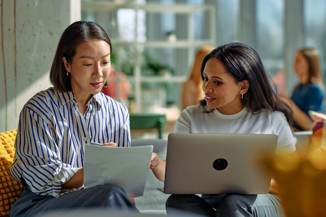 An Asian businesswoman mentors a female colleague